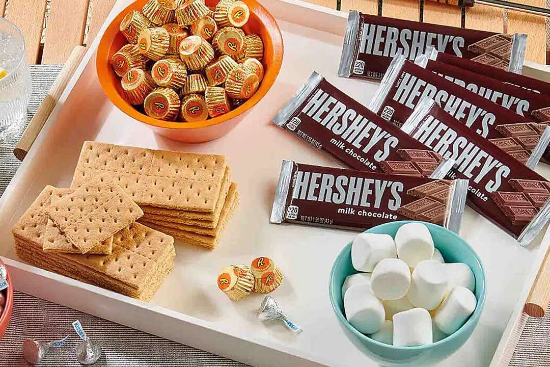 tray of hersheys milk chocolate candy bars, reeses peanut butter cups, marshmallows, and graham crackers